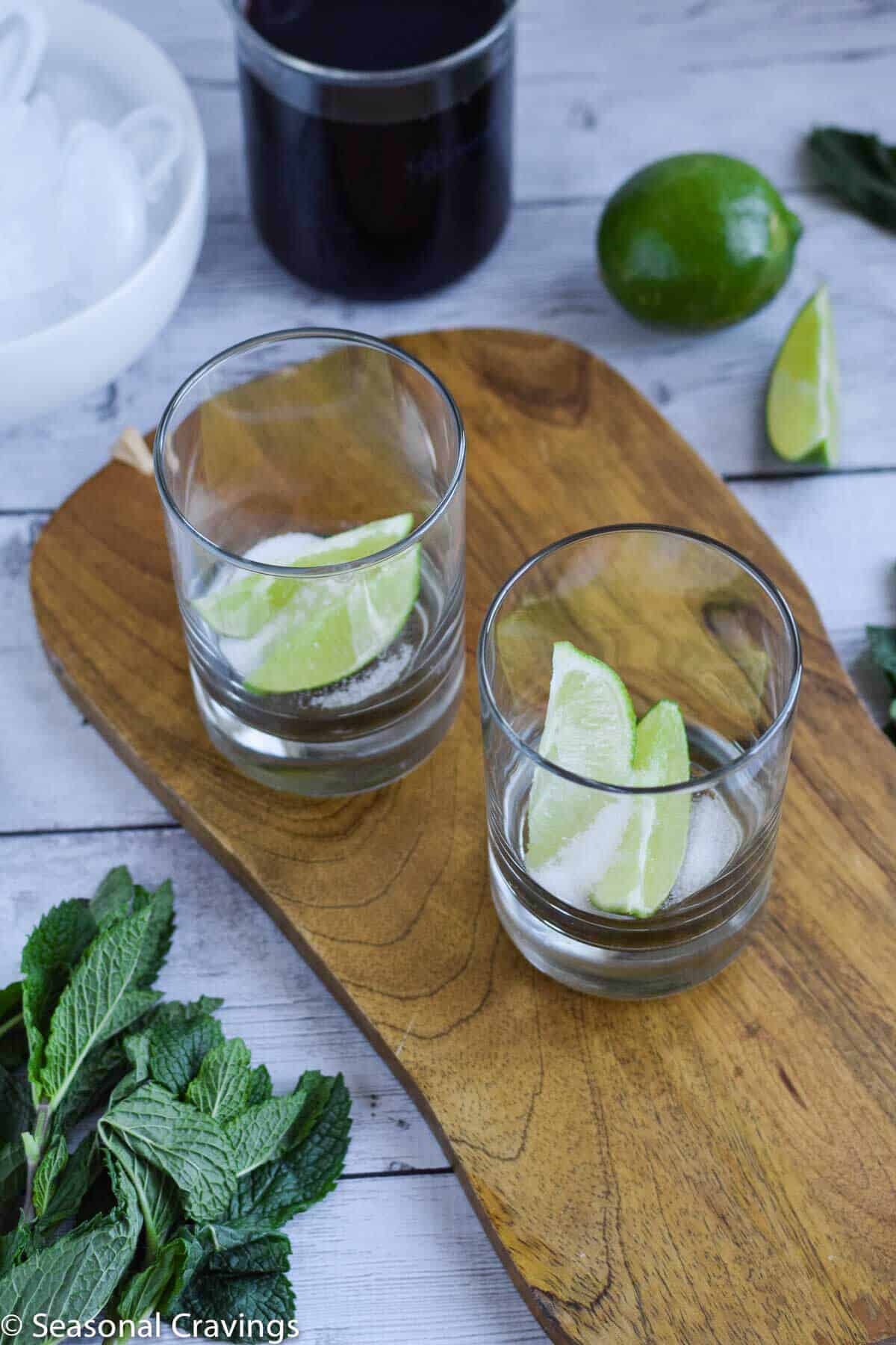 Easy Pomegranate Mojito with lime and sugar in glasses on a cutting board