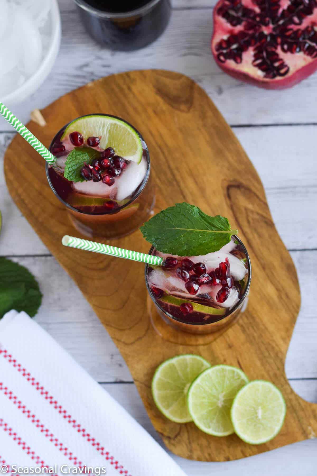 Easy Pomegranate Mojito on whale cutting board with limes