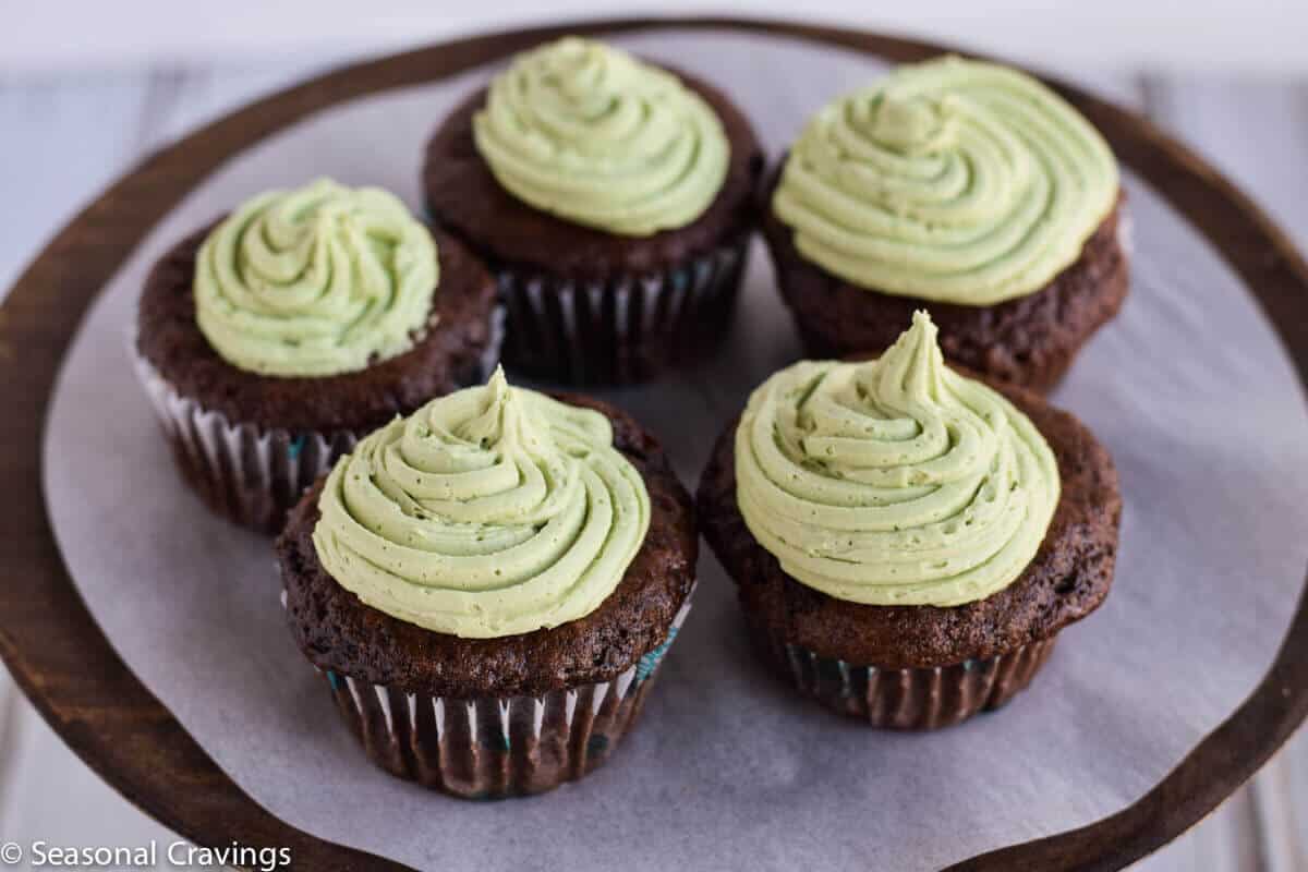 gluten free chocolate cupcakes with green buttercream frosting on a cake stand