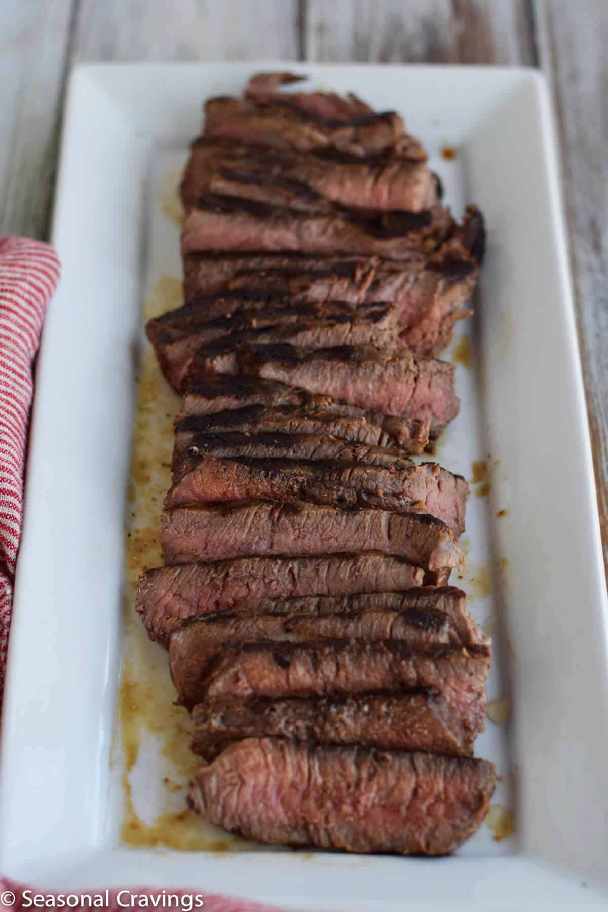 london broil round steak sliced on a white plate