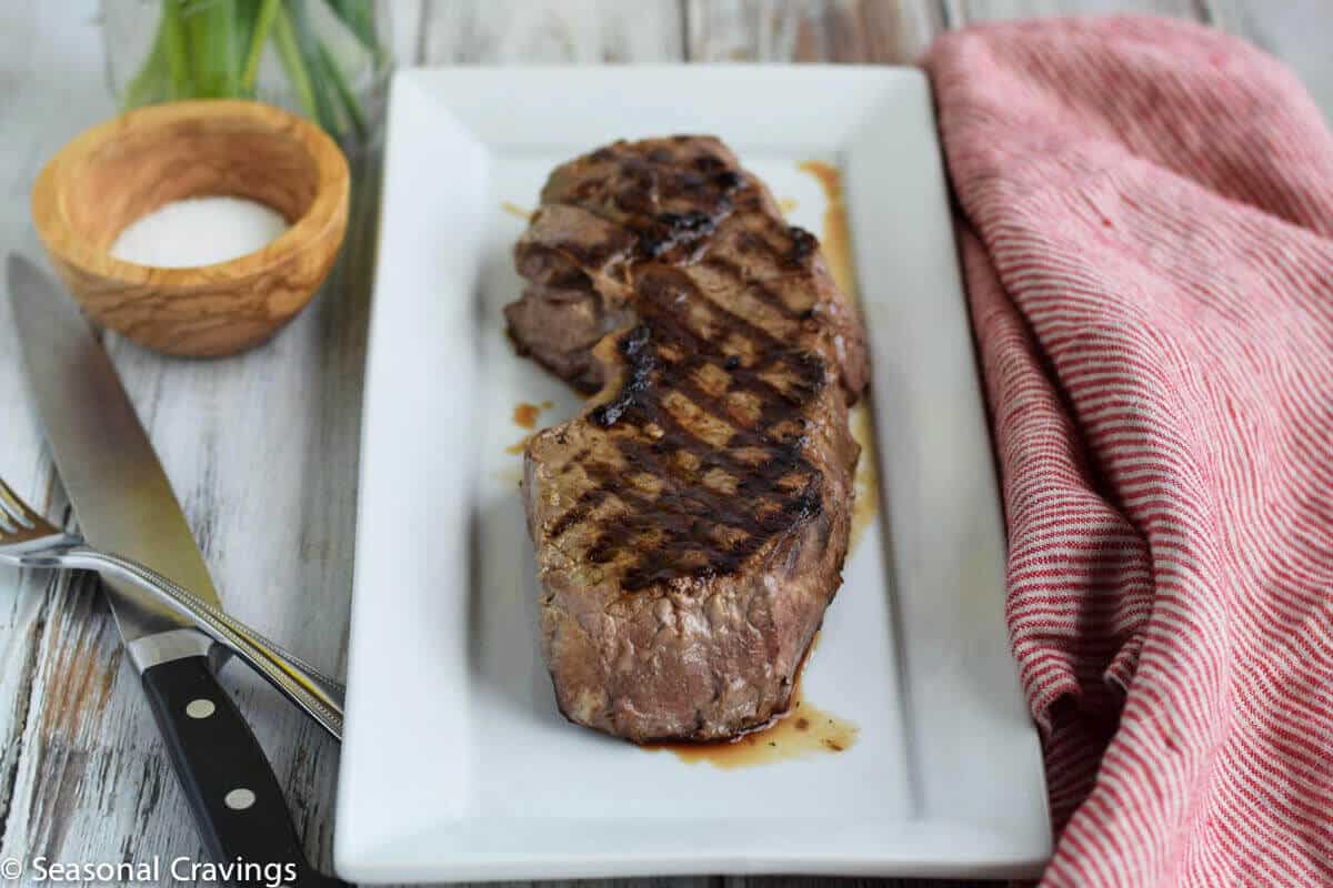 Tender London Broil on a white plate with knife