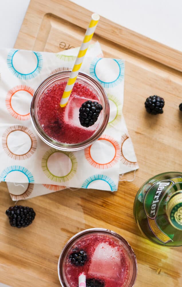 Blackberry-Lemon-Cocktails on a cutting board with napkins