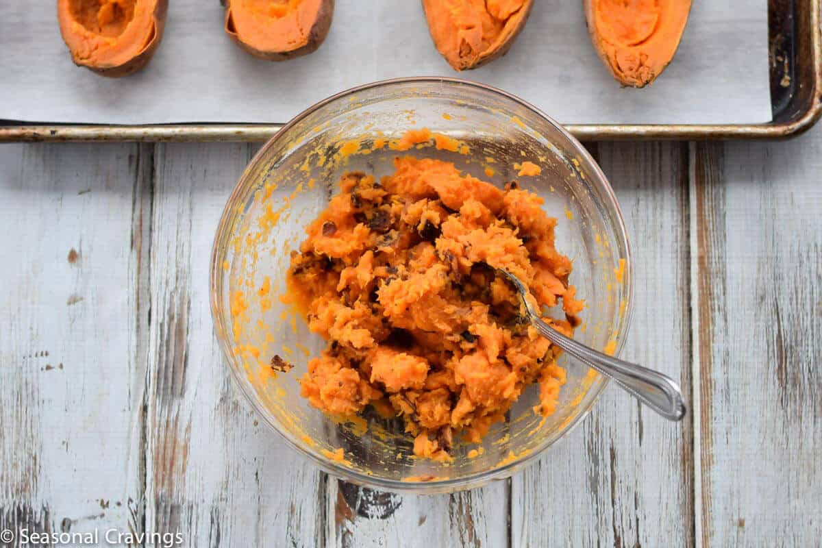 Baked Sweet Potatoes mashed in a bowl with a spoon