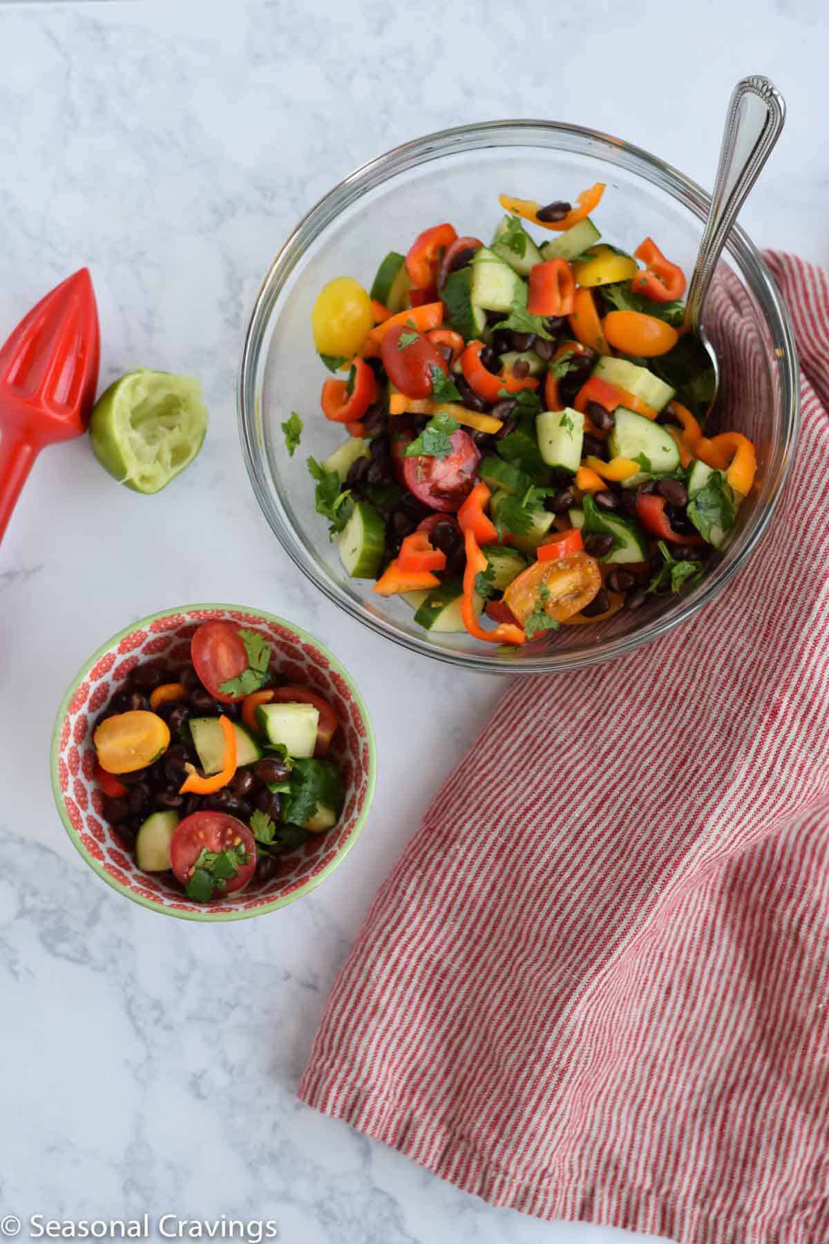 Skinny Cucumber and Tomato Salad in a bowl with a lime