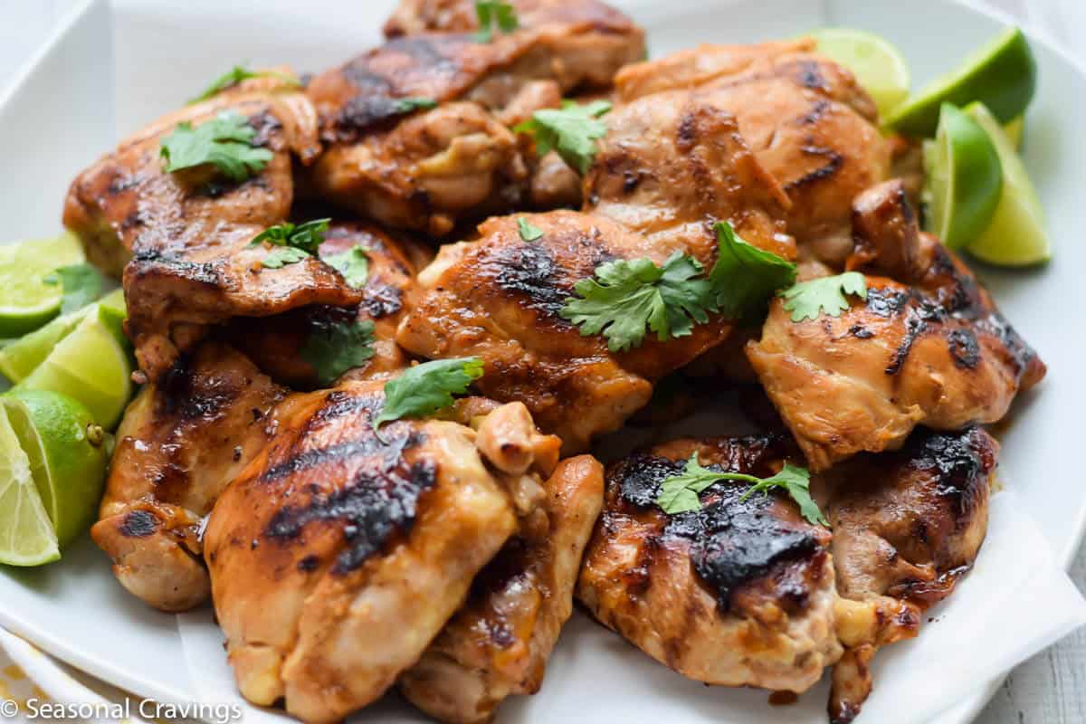 Ginger Honey Glazed Chicken on white plate with limes and parsley