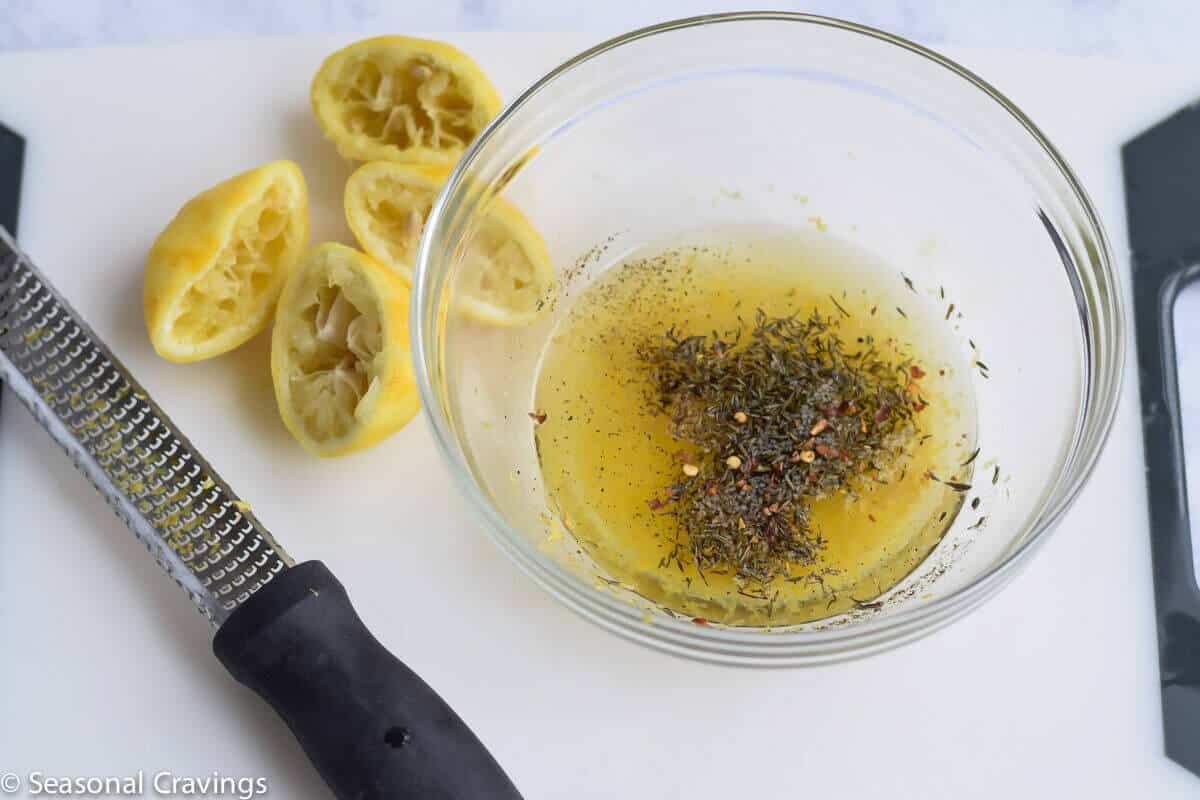 Chicken Souvlaki marinade in a bowl with lemons