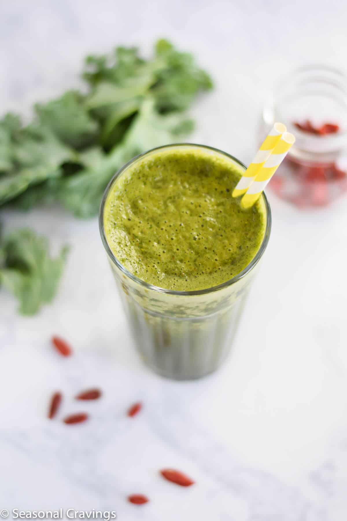 Green Goji Berry Smoothie in glass with kale on side