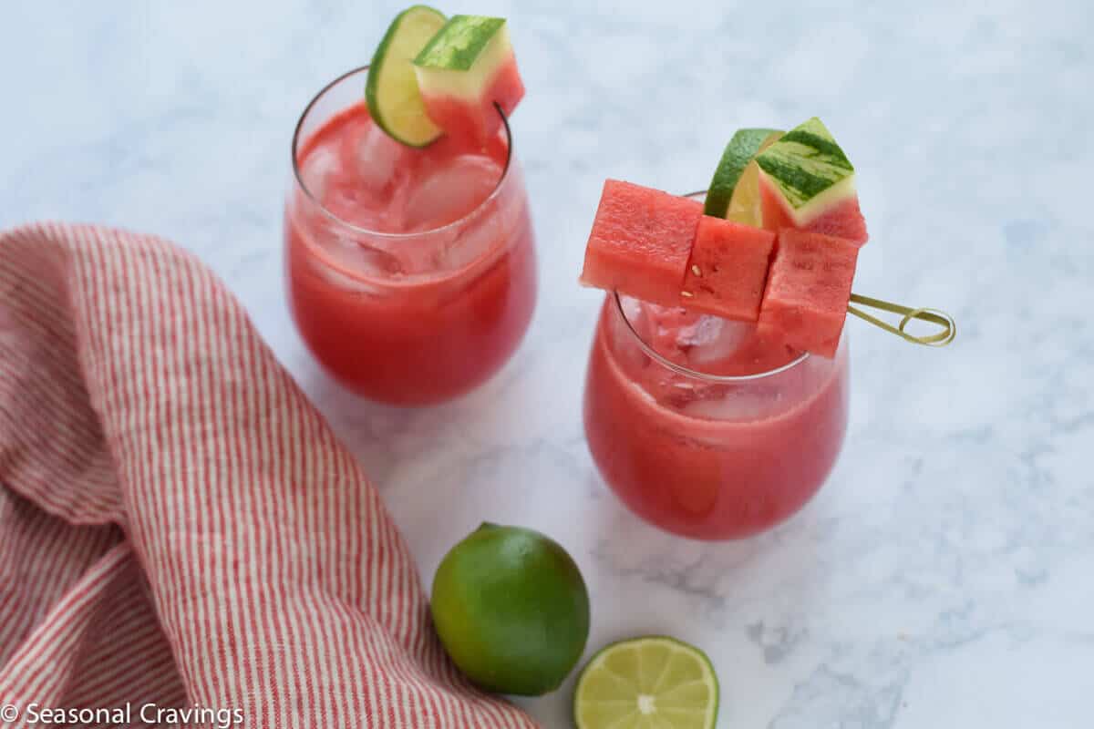 Watermelon Margaritas in two glasses with limes