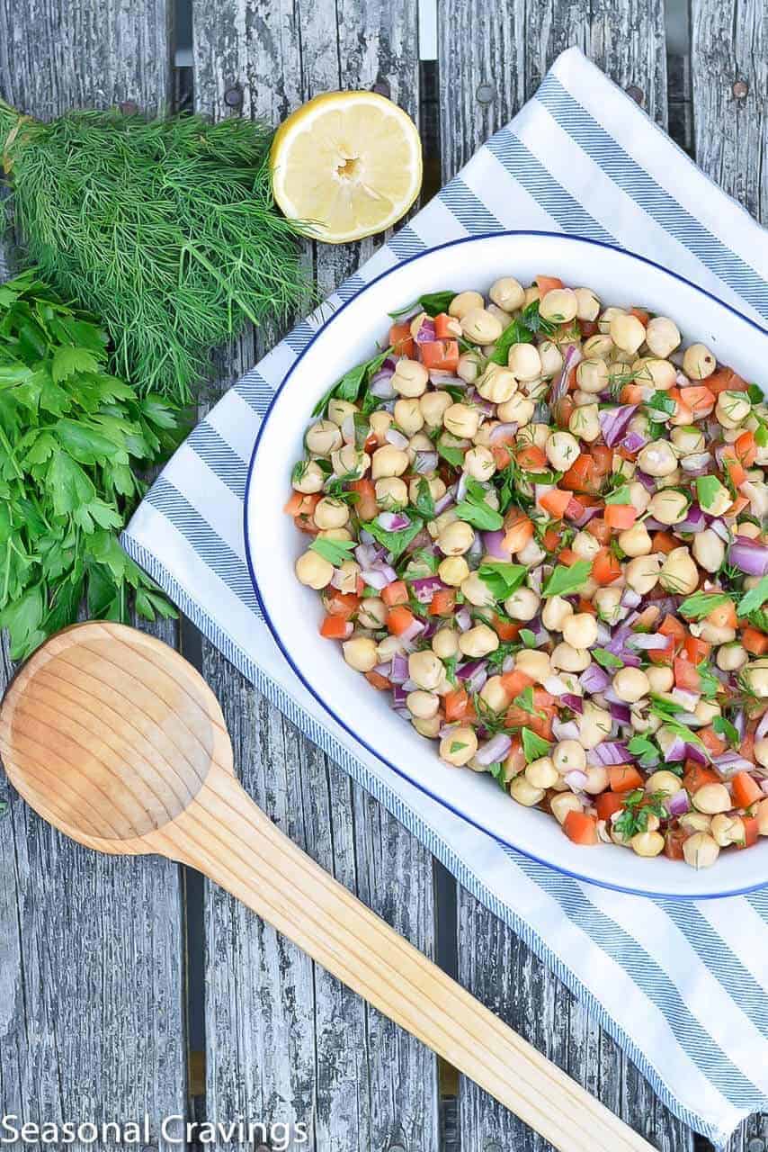 Summer Chickpea Salad with lemon and herbs on a wooden table