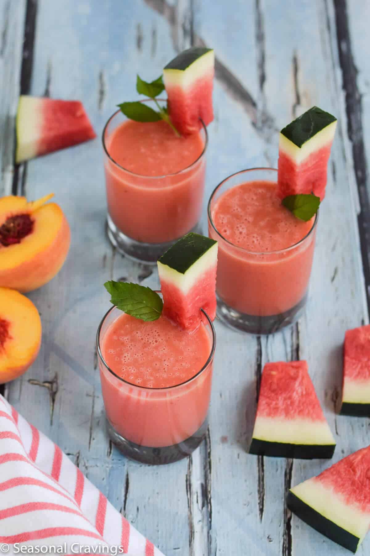 Watermelon Peach Smoothie in three glasses with watermelon garnish