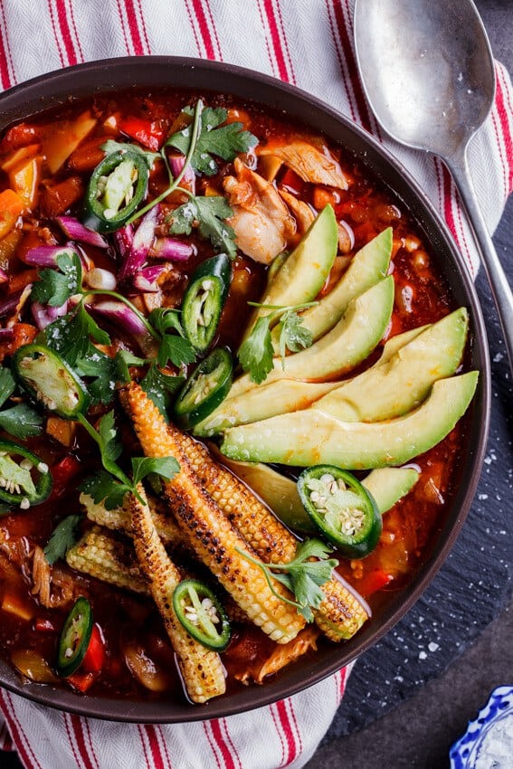 Mexican Chicken Soup with Charred Baby Corn with avocado in a bowl