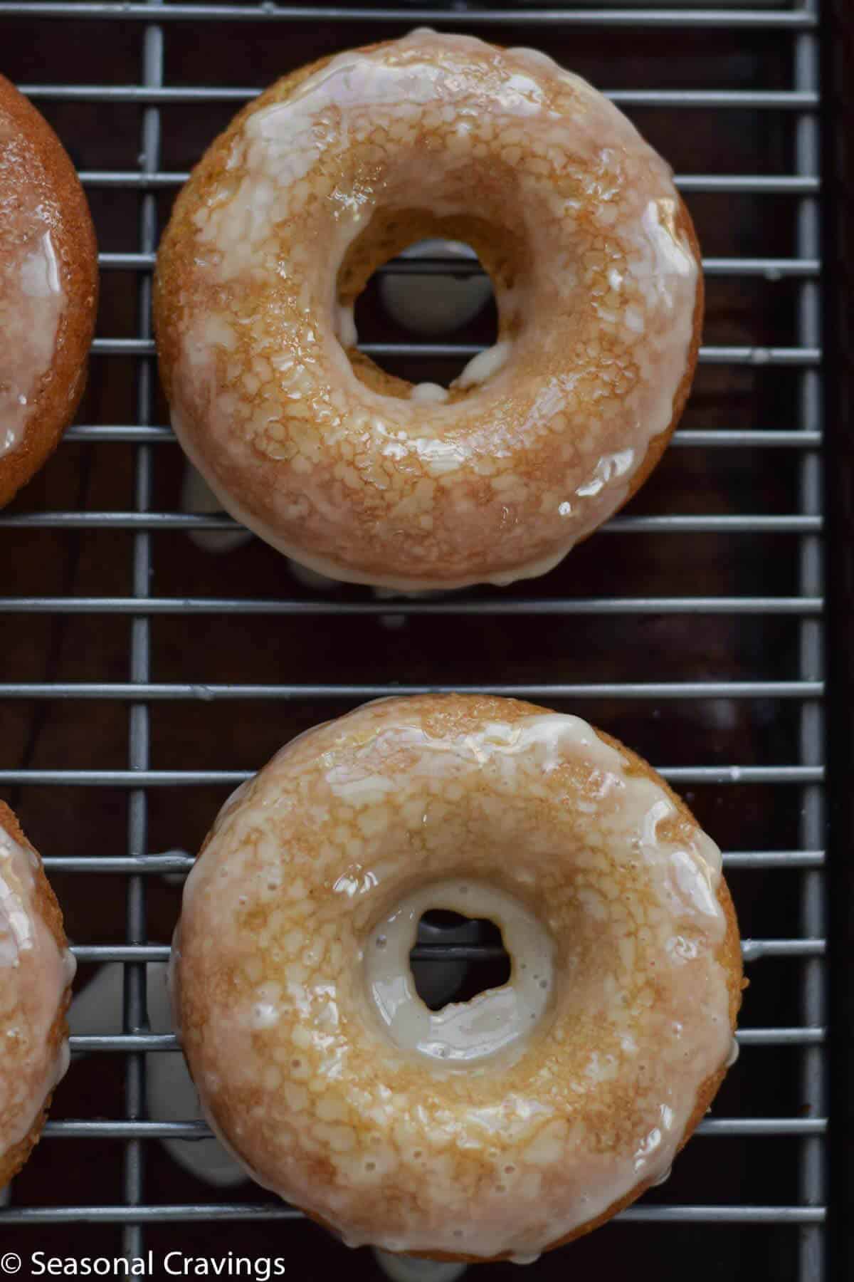  Gluten Free Apple Cider Doughnuts on a cooling rack with a sweet glaze