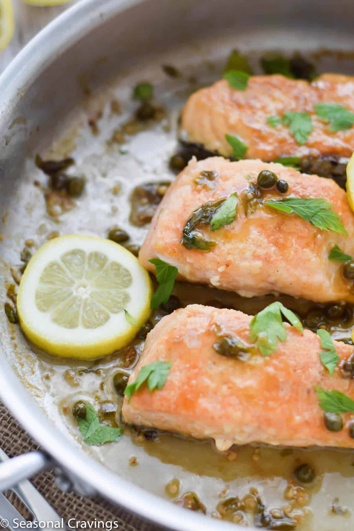 Close up of Gluten Free Salmon Piccata with lemon, capers and parsley in a white wine sauce