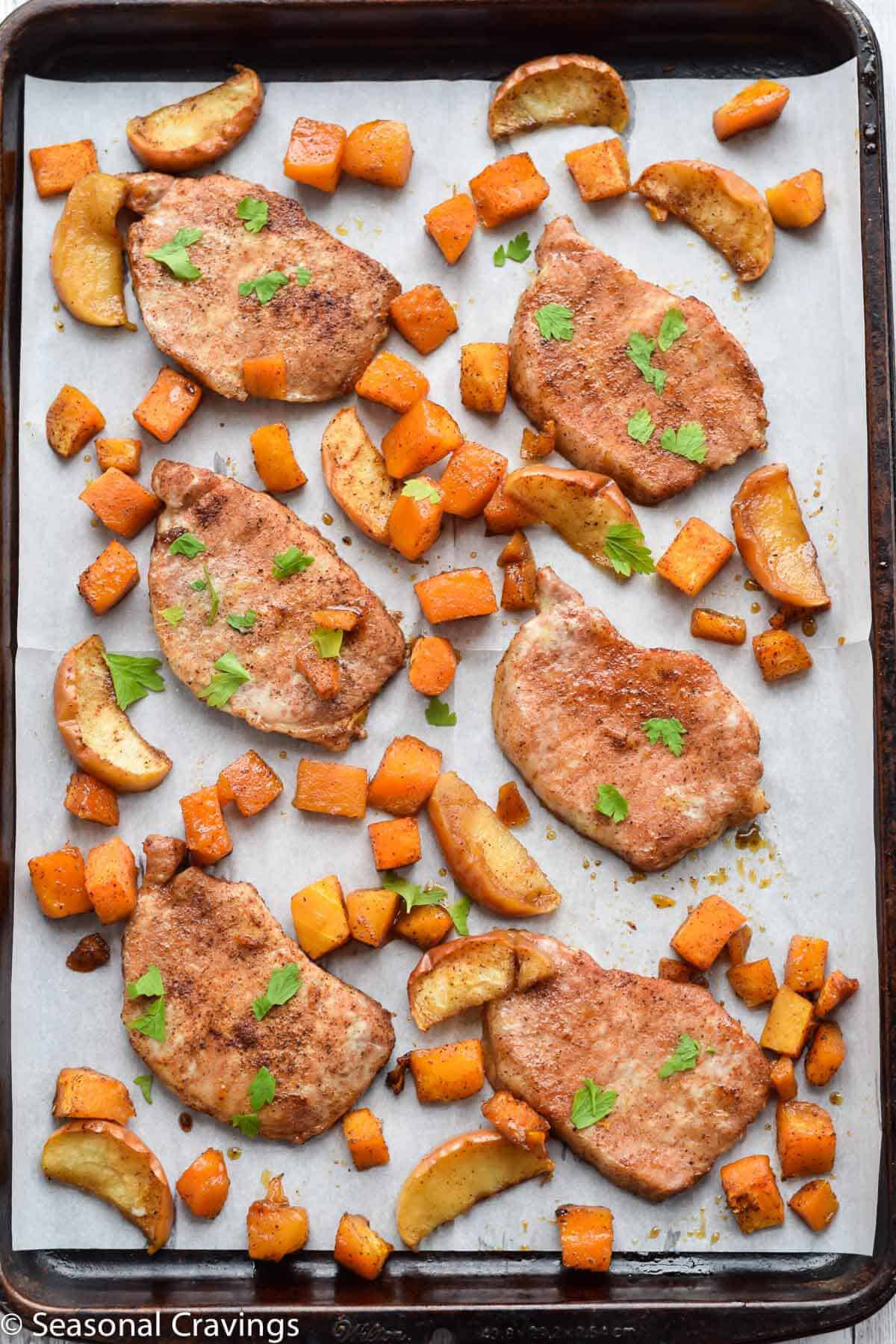 Sheet Pan Brown Sugar Pork Chops on parchment paper with parsley
