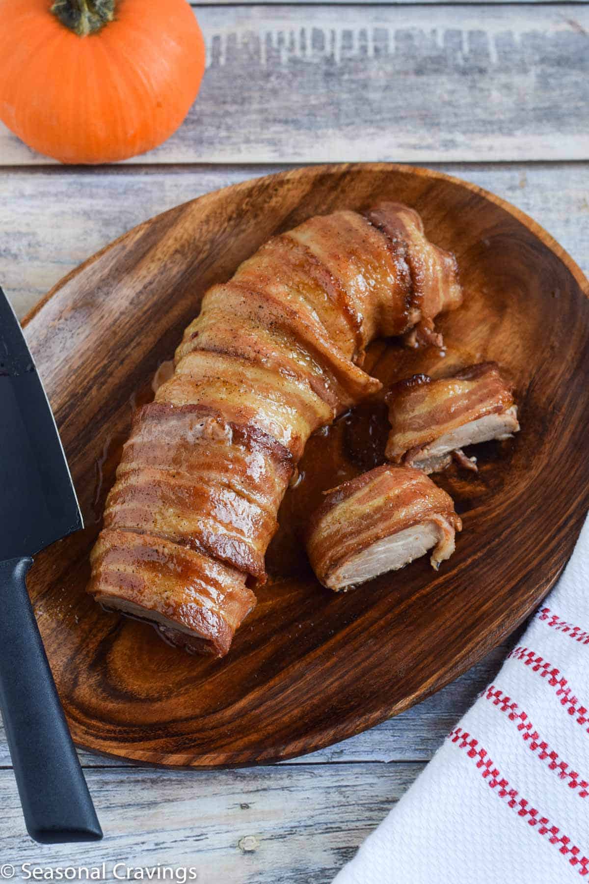 Maple Bacon Pork Tenderloin on a wooden dish with knife