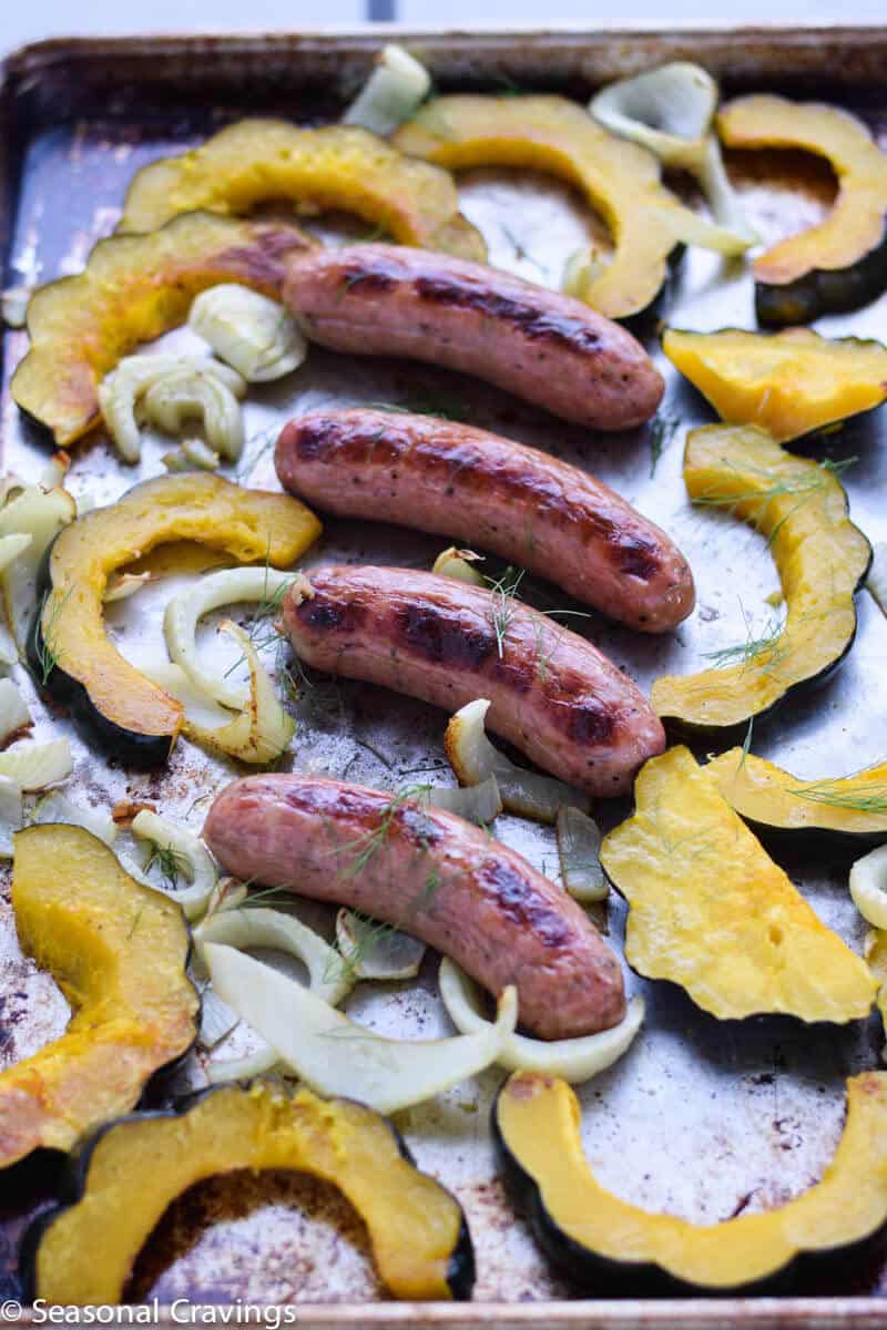 Sheet Pan Sausage and Acorn Squash and fennel with fresh dill on a sheet pan