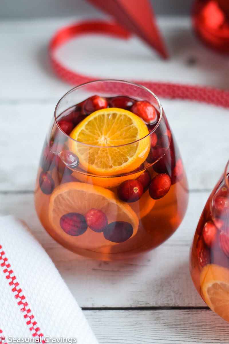 Five Ingredient White Sangria in a glass with oranges and cranberries