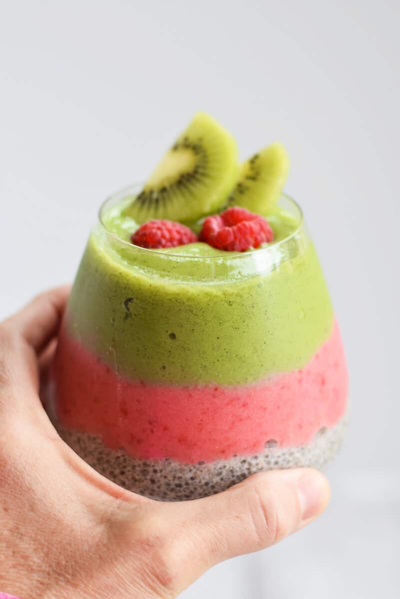 Kiwi and Raspberry Chia Pudding with a hand