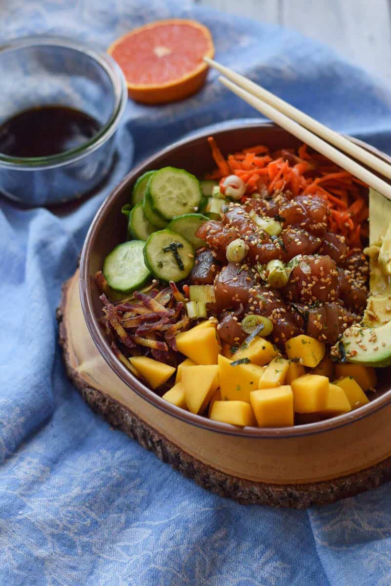 Tuna Poke Bowl with Mango and Quinoa - Sushi grade tuna with a salty dressing and a load of veggies all layered on a bed of quinoa.