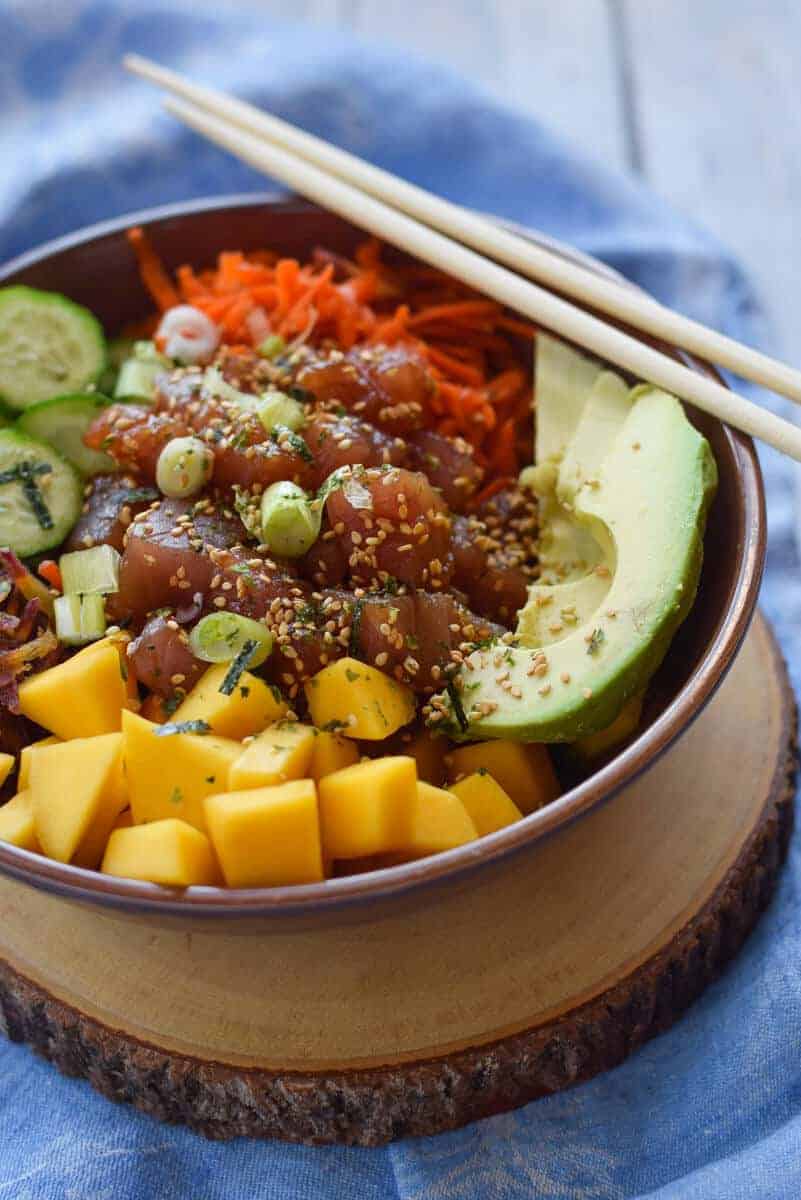 Tuna Poke Bowl with Mango and Quinoa - Sushi grade tuna with a salty dressing and a load of veggies all layered on a bed of quinoa.