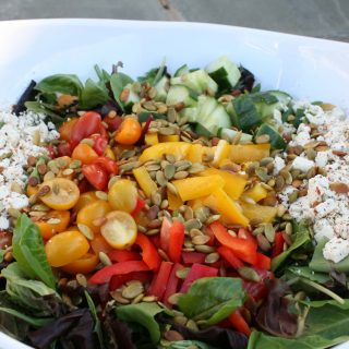 A white bowl filled with a colorful salad.