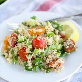 A plate of Quinoa Tabbouleh salad with tomatoes and cucumbers.