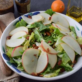 A salad with apples and walnuts in a bowl.