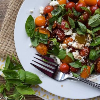 A plate with Grilled Tomato Salad with feta and basil on it.
