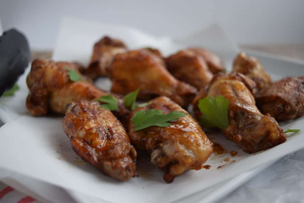 Easy Five Spice Chicken Wings on parchment with green parsley