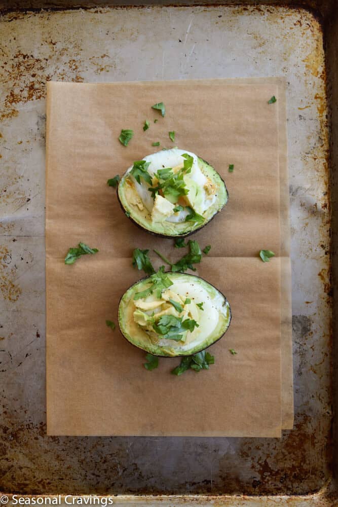 Baked Avocado with Egg on a sheet pan with parsley