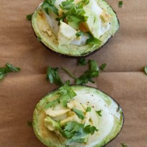 Baked avocados with eggs and herbs on top.