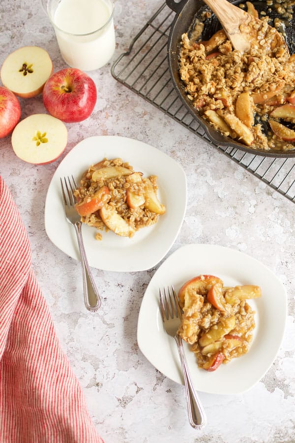 apple crisp with oats in plates with apples on side