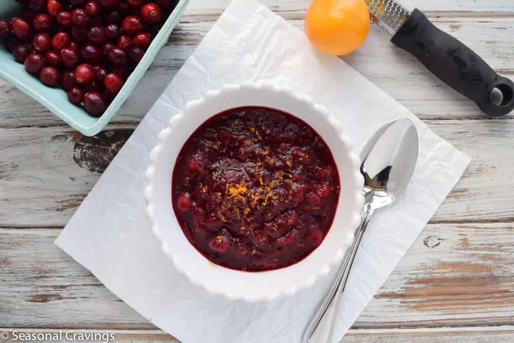 Cranberry Pomegranate Sauce close up in white bowl with spoon