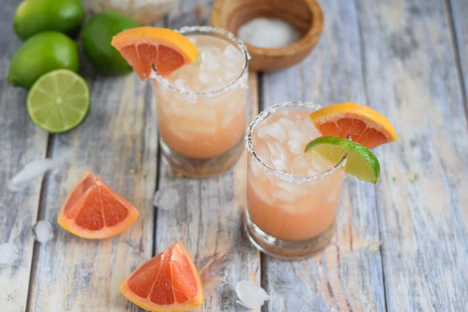 grapefruit margaritas in two glasses with salt