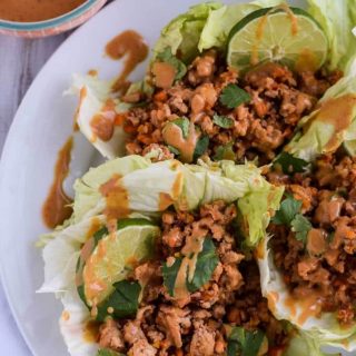 Thai chicken lettuce wraps on a white plate.