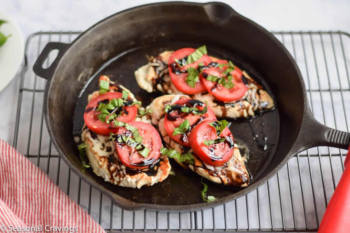 Easy Caprese Chicken in a cast iron skillet.