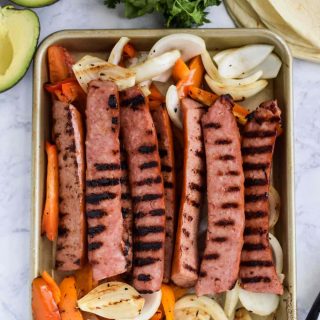Grilled sausage and vegetables on a baking sheet.