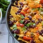 Fresh corn and bean nachos cooked in a cast iron skillet.