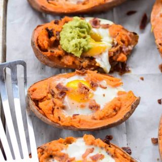 Baked sweet potatoes with eggs on a baking sheet.