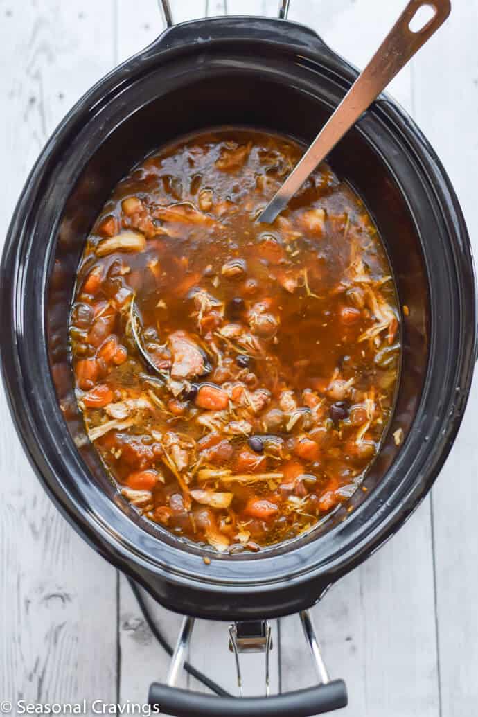 Slow Cooker Mexican Chicken Tortilla Soup with avocado, jalapenos and cheese in two small white serving bowls. #crockpot #glutenfree