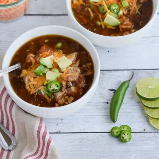 Two bowls of slow cooker Mexican chicken soup on a wooden table.