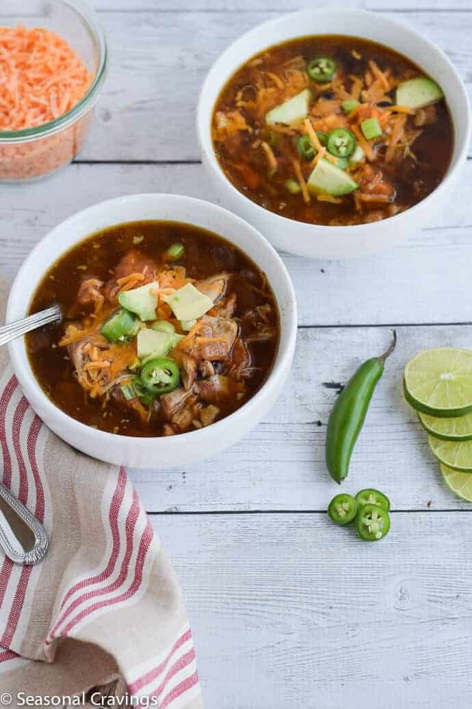 Slow Cooker Mexican Chicken Tortilla Soup with avocado, jalapenos and cheese in two small white serving bowls.  #crockpot #glutenfree