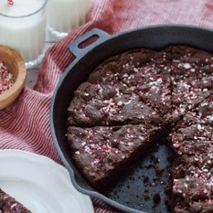 Chocolate peppermint cake in a skillet with a slice taken out.