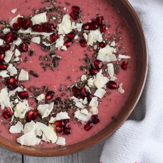 A pomegranate smoothie bowl with a hint of chocolate.