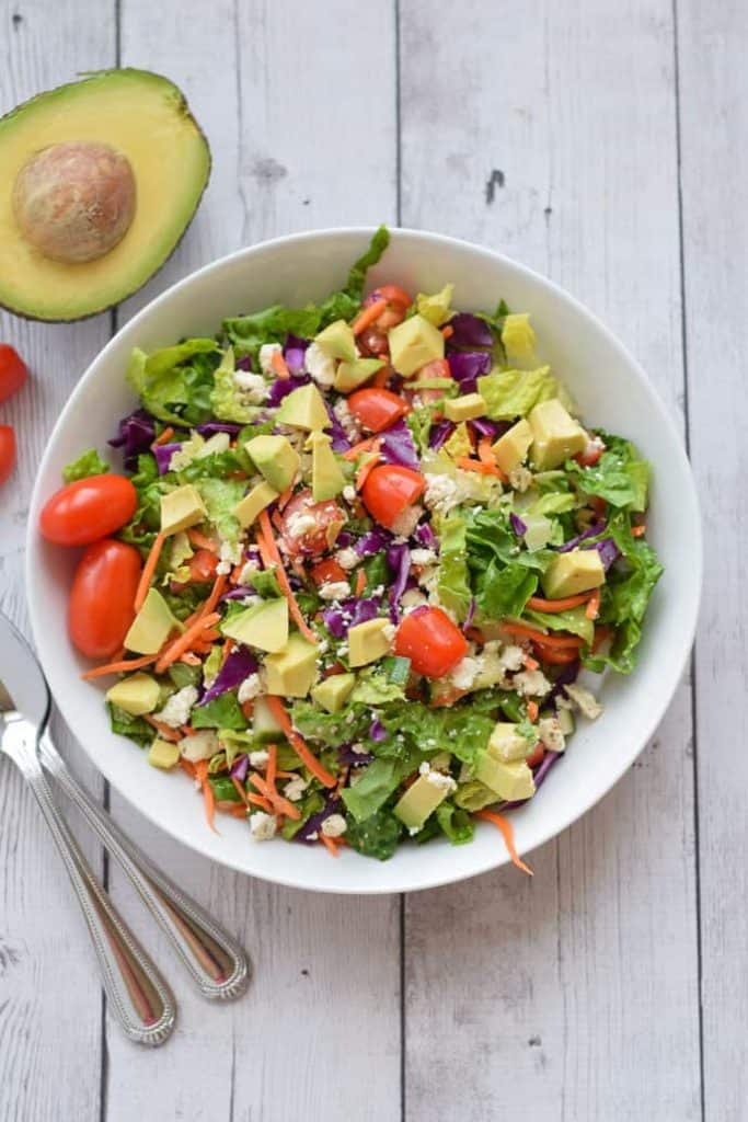 Healthy Chopped Sala with avocado in white bowl