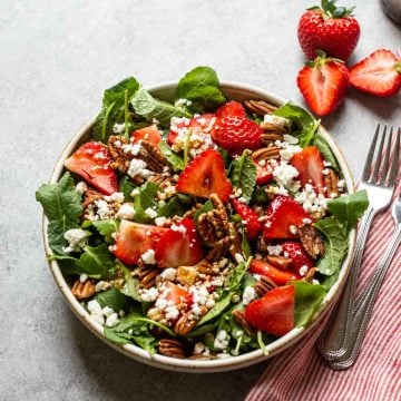 strawberry and pecan salad with feta cheese in a white bowl