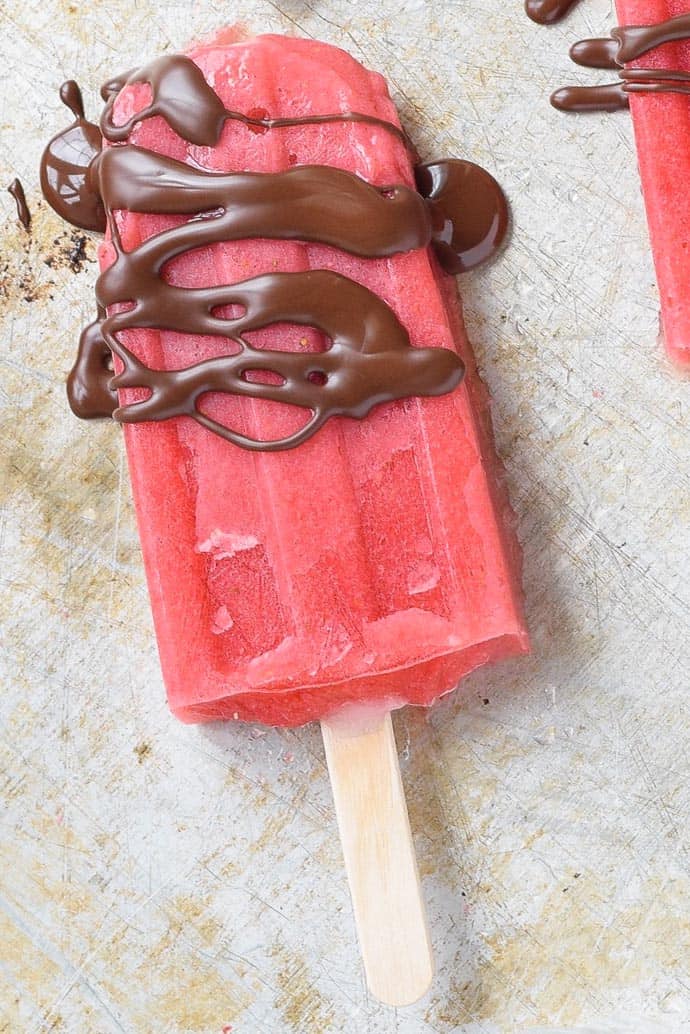 homemade Strawberry Popsicles close up with chocolate