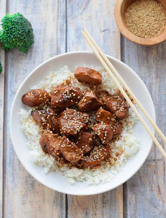 Instant Pot Sesame Chicken in a white bowl with chopsticks