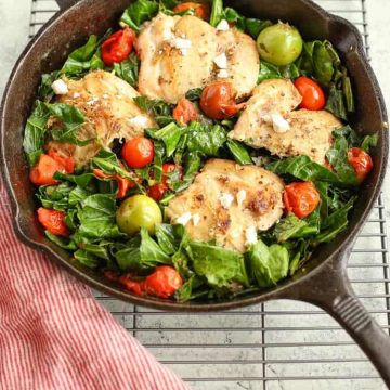 Mediterranean Skillet Chicken with Greens in a cast iron pan