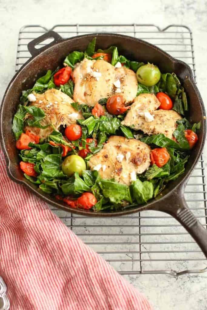 Mediterranean Skillet Chicken with Greens in a cast iron pan